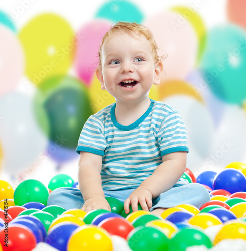 Photo: Cute boy playing colorful balls Cute boy playing colorful balls