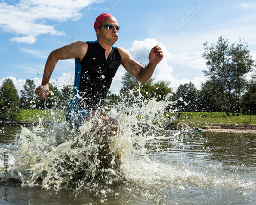 Photo: Triathlet rennt aus dem Wasser Triathlet rennt aus dem Wasser