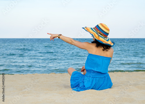 Photo: Woman pointing to the ocean Woman pointing to the ocean