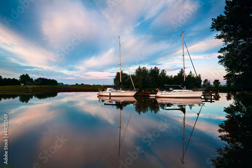 Photo: two yachts on river at sunrise two yachts on river at sunrise