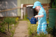 Foto: Kind läuft mit Gießkanne durch Garten Kind läuft mit Gießkanne durch Garten