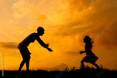 Photo: Silhouettes of mother and daughter meeting on the meadow Silhouettes of mother and daughter meeting on the meadow