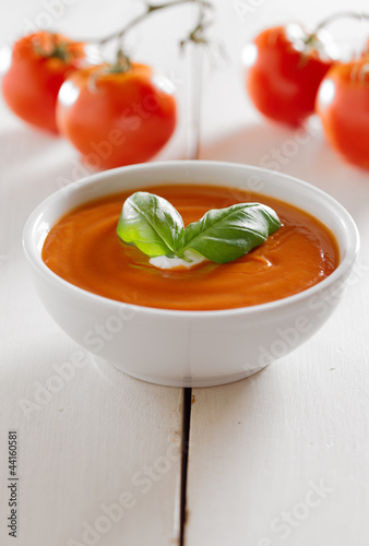 Photo: tomato soup with basil garnish and copyspace composition tomato soup with basil garnish and copyspace composition