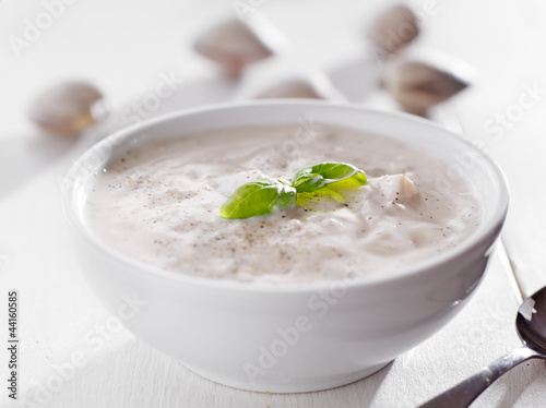Photo: Bowl of new england clam chowder with basil garnish. Bowl of new england clam chowder with basil garnish.