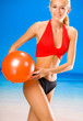 Photo: Young woman playing with ball on beach Young woman playing with ball on beach