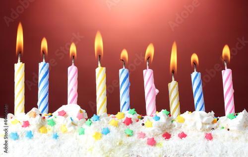 Photo: beautiful birthday candles on red background beautiful birthday candles on red background