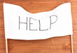 Help written on white cloth on wooden background