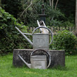 Alter Brunnen mit Gießkannen im Garten