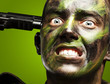 portrait of young soldier comiting suicide over green background