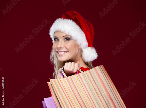 Photo: Beautiful woman in Christmas cap hands shopping packets Beautiful woman in Christmas cap hands shopping packets