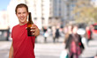portrait of young man holding beer at crowded street