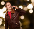 portrait of young man drinking beer against a abstract lights ba
