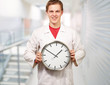 Portrait of a doctor holding a clock