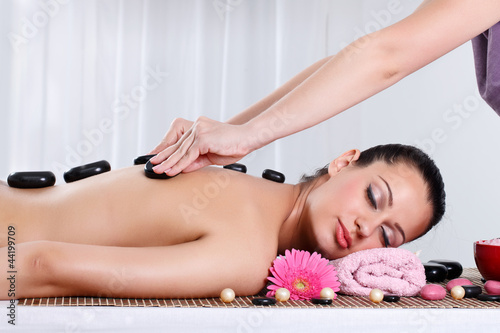 Photo: Beautiful woman receiving hotstone massage at spa Beautiful woman receiving hotstone massage at spa