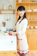 Photo: Beautiful young woman in the kitchen. Portrait of asian. Beautiful young woman in the kitchen. Portrait of asian.