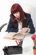 Confident business woman reads book in a office
