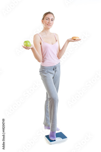 Photo: young beautiful woman choosing between burger and apple young beautiful woman choosing between burger and apple