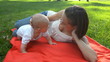 Vídeo : happy mother with son lying on red rug in park happy mother with son lying on red rug in park