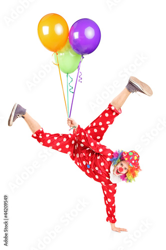 Photo: Clown holding balloons and standing on one hand Clown holding balloons and standing on one hand