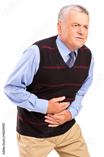 Photo: Mature man overwhelmed with a pain in the stomach Mature man overwhelmed with a pain in the stomach
