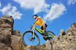 Person riding a mountain bike amid rocks on a sunny day against