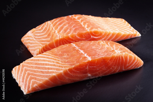 Photo: Piece of raw fresh salmon isolated on black background Piece of raw fresh salmon isolated on black background