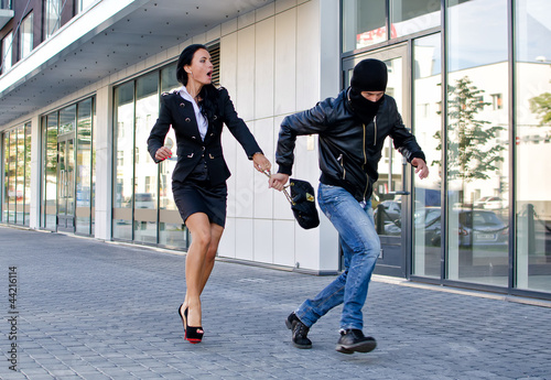 Photo: Bandit stealing businesswoman bag in the street Bandit stealing businesswoman bag in the street