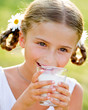Healthy kid - lovely girl drinking fresh milk outdoors