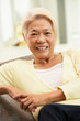 Senior Chinese Woman Relaxing On Sofa At Home