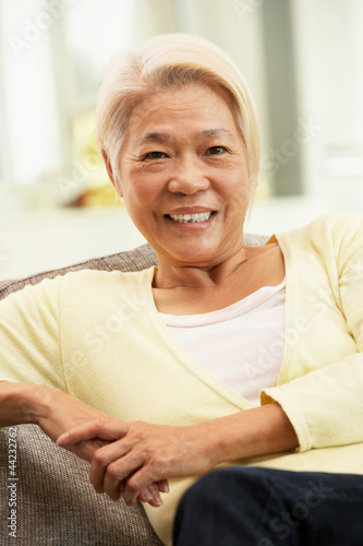 Photo: Senior Chinese Woman Relaxing On Sofa At Home Senior Chinese Woman Relaxing On Sofa At Home