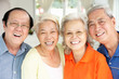 Group Of Senior Chinese Friends Relaxing On Sofa At Home