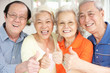 Group Of Senior Chinese Friends Relaxing On Sofa At Home
