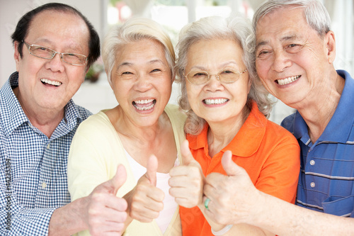 Photo: Group Of Senior Chinese Friends Relaxing On Sofa At Home Group Of Senior Chinese Friends Relaxing On Sofa At Home