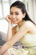 Young Chinese Woman Relaxing On Sofa At Home