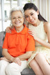 Portrait Of Chinese Mother With Adult Daughter Relaxing At Home