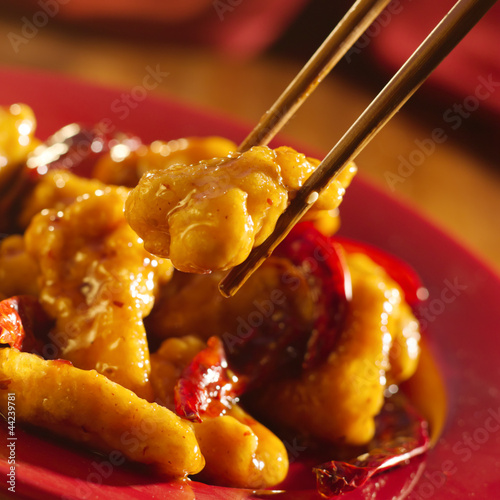 Photo: Chinese food - Eating general tso's chicken with chopsticks. Chinese food - Eating general tso's chicken with chopsticks.