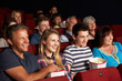 Foto: Teenage Family Watching Film In Cinema Teenage Family Watching Film In Cinema