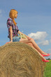 Photo: girl sitting on straw bale girl sitting on straw bale