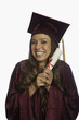 graduate in cap and gown with diploma