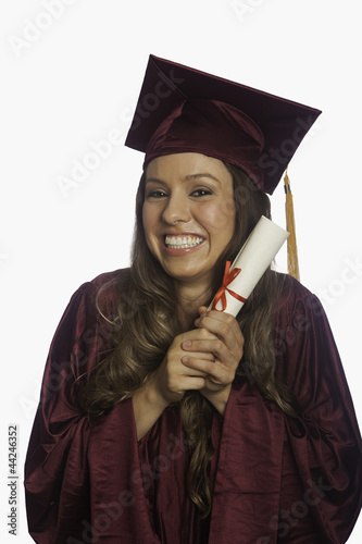 Photo: graduate in cap and gown with diploma graduate in cap and gown with diploma