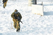 paintball player with marker at winter outdoors