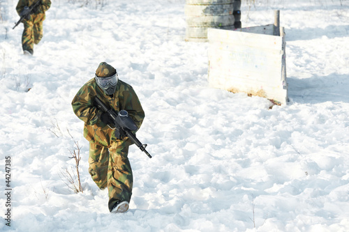 Photo: paintball player with marker at winter outdoors paintball player with marker at winter outdoors