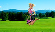 Frau im Dirndl spring auf Wiese