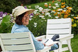 woman with book and e-book in the garden