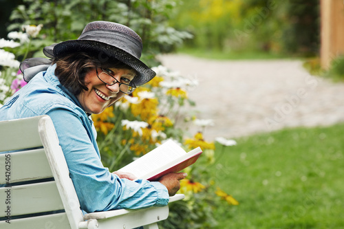 Photo: woman reading a book in the garden woman reading a book in the garden