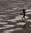 Niña jugando en la orilla del mar