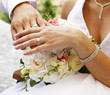 Hands and rings on wedding bouquet