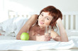 Photo: attractive young woman with an green apple and glass of water attractive young woman with an green apple and glass of water