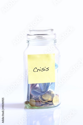 Photo: Glass jar with coins for crisis. Glass jar with coins for crisis.