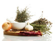 dried herbs in mortar and vegetables, isolatrd on white